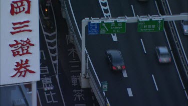 Closeup on two layers of traffic in Tokyo, filmed from above.