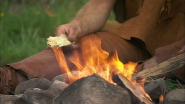 Close up of a man sitting by fire