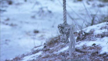 The end of a rope swing with a snowy background