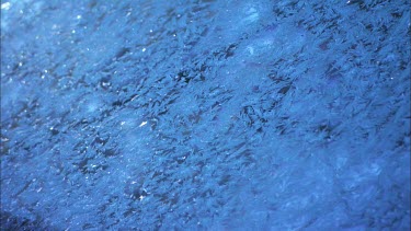 Close up of ice formed on a blue car.