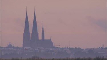 Close up of the Uppsala Cathedral at sundown, filmed from a distance.