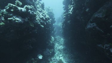 Through narrow passage of rocky coral outcrops.