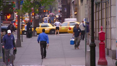 People walking along sidewalk, New york. Pavement. Pedestrians. Yellow cabs.