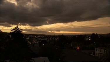 Hobart in the evening, clouds. Lights in town begin to switch on.