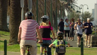 Family cycling, people walking and exercising in a park