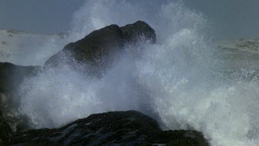 Big wave crashing on rock slomo
