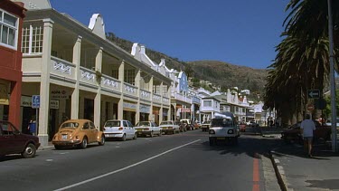 Simon's Town. Cape Town. Cars driving down street lined with Cape Dutch heritage buildings