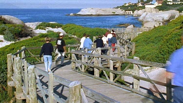 People walking along coastal boardwalk