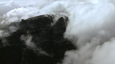 Detail of cloud tumbling over side of mountain