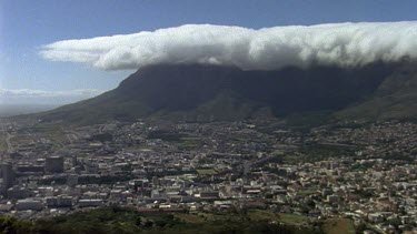 City of Cape Town with Table Mountain in background, covered with thick white "tablecloth" of cloud