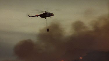 Helicopter drops water over raging fire