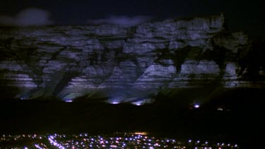 Table Mountain at night with "tablecloth" of clouds over it. City of Cape Town at foot of mountain.