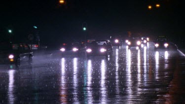 Cars driving on wet roads at night