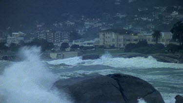 Stormy seas. Waves crashing. City in bg.
