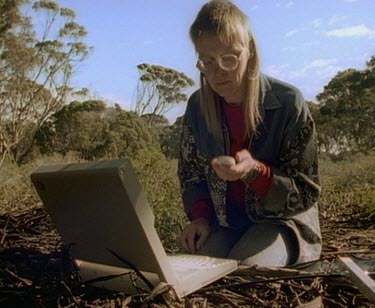 Scientist with laptop and information from radio tag transmitter.