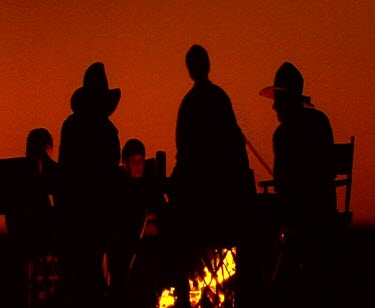 Cowboys with campfire at sunset. Silhouette. Flames.