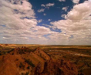 Clouds and outback desert red rocky land and shadows