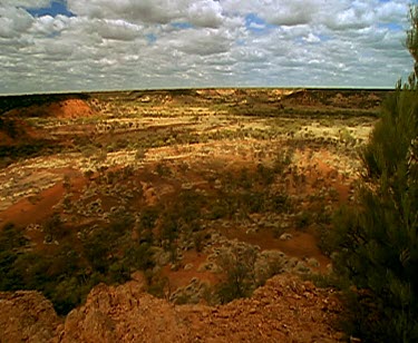 Clouds and outback desert red rocky land and shadows