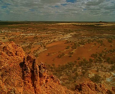 Clouds and outback desert red rocky land