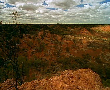 clouds and outback desert red rocky land and shadows