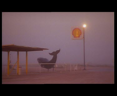 Nullarbor petrol station. Gas station. A fibreglass whale marks the entrance to the petrol station. The air is very dusty. Sunset. Whales tale Tavern