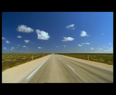 Driving on Nullarbor Plain. Big dramatic blue sky.