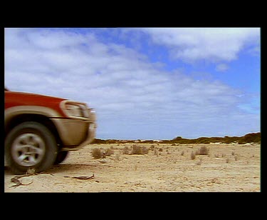 4wd four-wheel drive driving over very white sand dunes. Wheel getting stuck in sand.