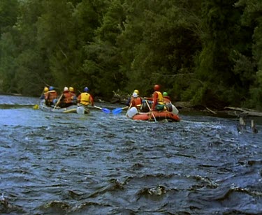 Rafting down river, paddling over rapids