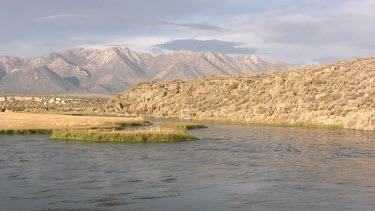 A pristine river runs through a  desert valley