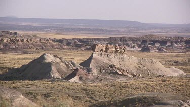 Grassy desert valley with mounds, buttes and mesas
