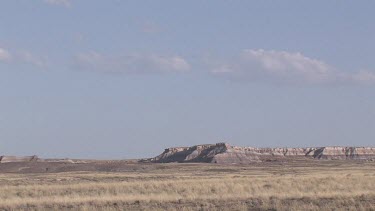 Grassy desert prairie plains valley with mesas in the distance