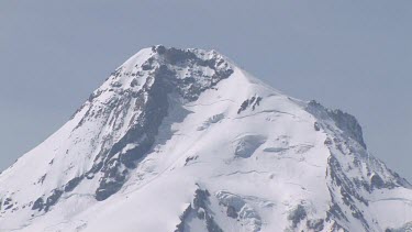Mountain with snowy peak against sky