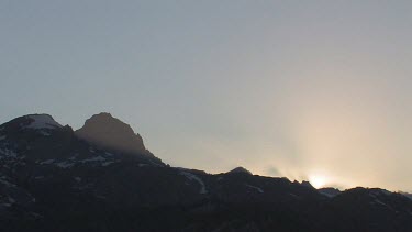 Sunrise or sunset behind mountain range