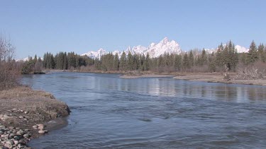 a broad blue Rocky Mountain river in Spring; the Snake River
