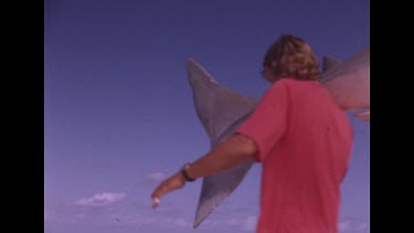men carry shark out of frame low angle