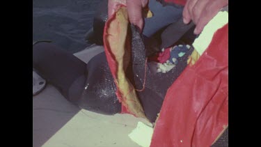 man inspecting tear in dummy