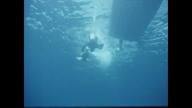 Henri diving underwater, holding camera