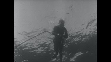 black and white, diver inspects bent spear