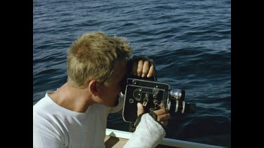 boy with cast videoing on the boat