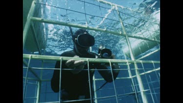 Underwater cinematographer diver in cage