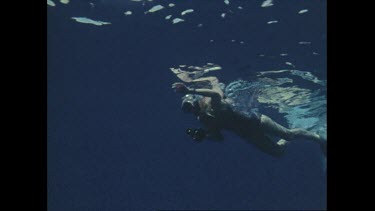 snorkeller dives under water