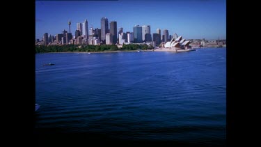 Sydney Harbour with Sydney Opera House and Harbour Bridge. A ferry crosses the Harbour.