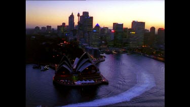 Sydney in early evening. City lights shining. Opera House, Circular Quay