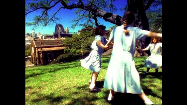 School girls in uniform dancing and playing. Sydney Harbour Bridge in background.