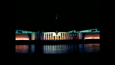 Parliament House at night, reflections in pool.