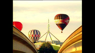 hot air balloons with parliament in background
