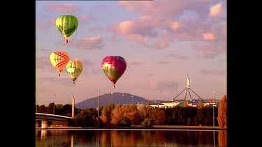 hot air balloons with parliament in background