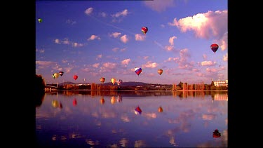 Hot air balloons over Lake Burley Griffin, scattered clouds in the sky.