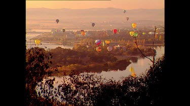 Hot air balloons suspended in the air over lake
