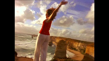 Woman with outstretched arms at Twelve Apostles, Great Ocean Road